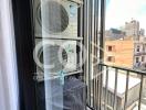Balcony view with air conditioning units and urban backdrop