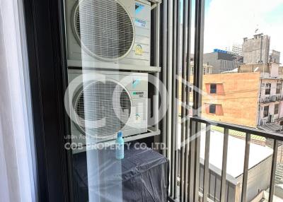 Balcony view with air conditioning units and urban backdrop