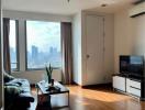 Bright living room with city view, hardwood floors, and modern furnishings