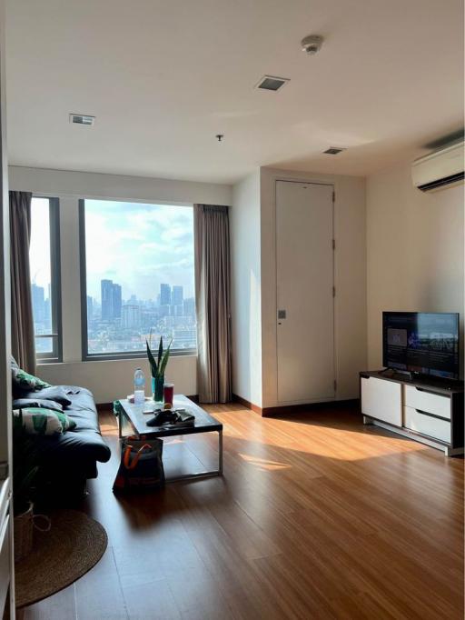 Bright living room with city view, hardwood floors, and modern furnishings