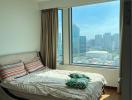 Modern bedroom with large window overlooking the city