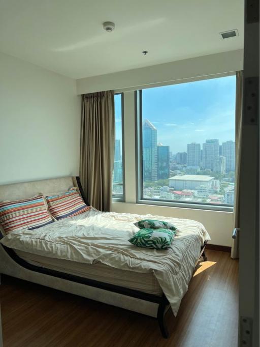 Modern bedroom with large window overlooking the city