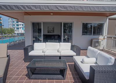 Spacious and furnished patio with comfortable seating and pool view