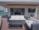 Spacious and furnished patio with comfortable seating and pool view
