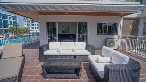 Spacious and furnished patio with comfortable seating and pool view