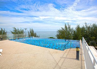 Outdoor infinity pool with ocean view and sunny sky