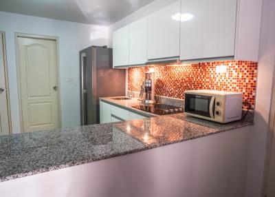 Modern kitchen with granite countertops and mosaic backsplash