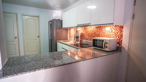Modern kitchen with granite countertops and mosaic backsplash
