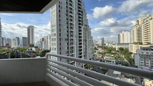 Spacious balcony with urban skyline and clear skies