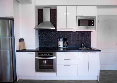 Modern kitchen with stainless steel appliances and black backsplash