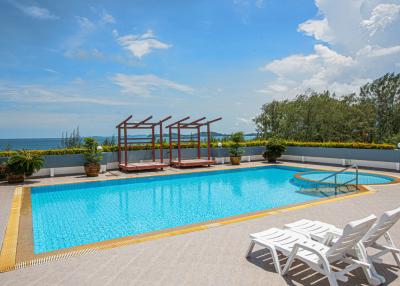 Outdoor swimming pool with sea view and lounge chairs