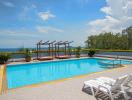 Outdoor swimming pool with sea view and lounge chairs