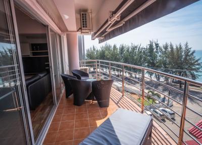 Spacious balcony with ocean view, seating arrangement, and sliding glass doors