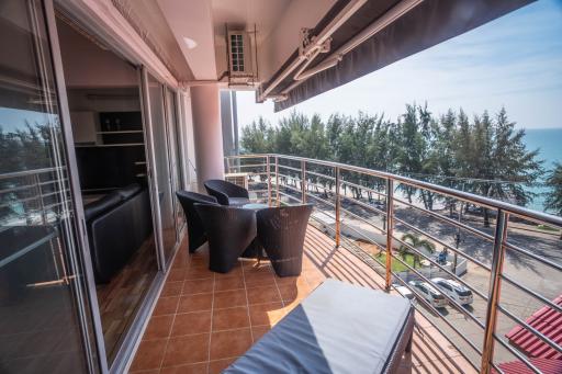 Spacious balcony with ocean view, seating arrangement, and sliding glass doors