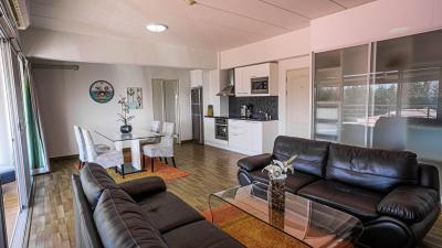 Spacious living room with open kitchen design, modern furniture, and ample natural light