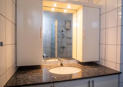 Modern bathroom interior with marble countertop and mirrored cabinet