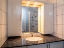 Modern bathroom interior with marble countertop and mirrored cabinet