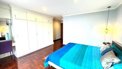 Spacious bedroom with large wardrobe and wooden flooring