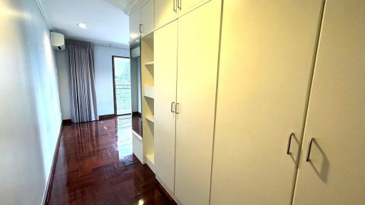 Spacious bedroom with built-in wardrobe and hardwood flooring