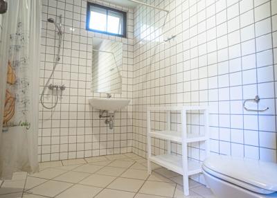 Bright tiled bathroom with a small window