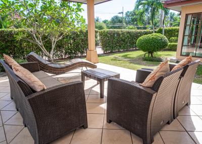 Spacious and well-appointed patio area with comfortable seating and lush garden views