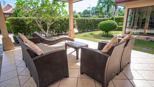 Spacious and well-appointed patio area with comfortable seating and lush garden views