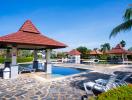 Resort-style community pool surrounded by palm trees with loungers and cabanas