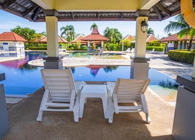 Sun loungers by a communal outdoor swimming pool in a residential complex