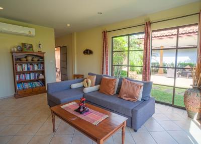 Spacious living room with large windows and comfortable seating