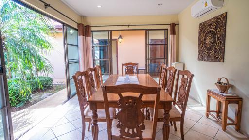 Spacious dining room with large wooden table and sliding glass doors to the garden