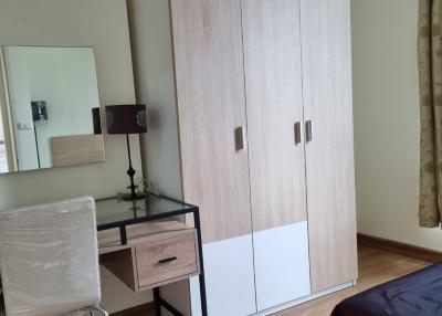 Contemporary bedroom interior with wardrobe, chair, and side table