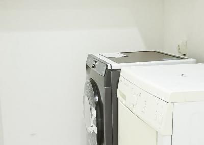 Compact laundry room with modern appliances and ample shelving