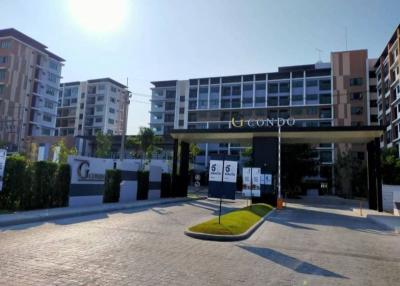 Front entrance of a modern residential condo complex with sunny skies