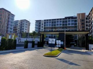 Front entrance of a modern residential condo complex with sunny skies