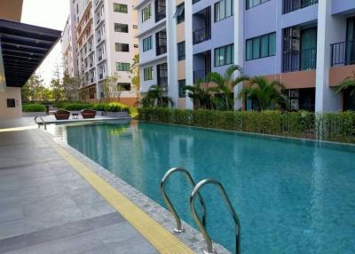 Swimming pool with lounging chairs outside a modern residential building