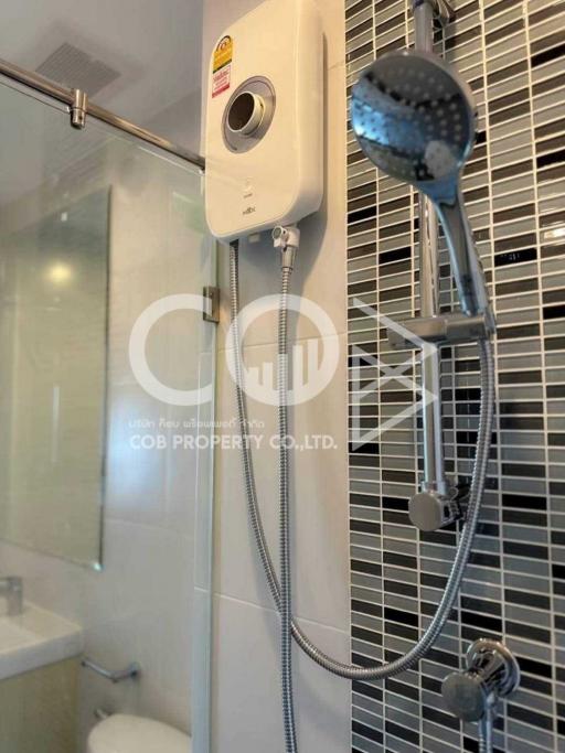 Modern bathroom with tiled walls and electric shower unit