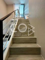 Modern wooden staircase with metal railing inside a residential building