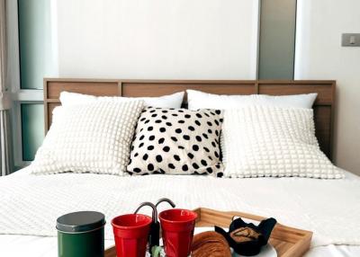 Cozy bedroom with artistic wall decor and breakfast tray on bed
