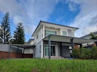 Modern two-story house with spacious lawn and clear skies