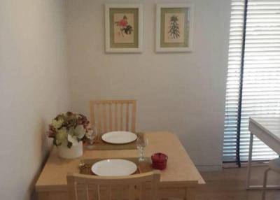 Cozy dining space with wooden table and chairs, decorated with wall art and blinds