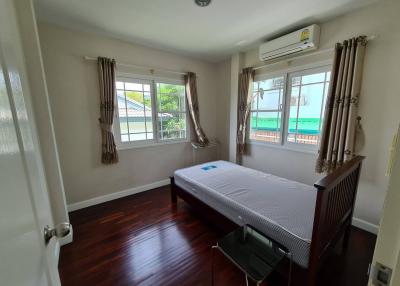 Spacious bedroom with hardwood floors, large windows, and air conditioning unit