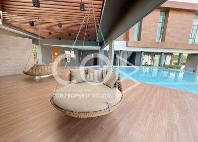 Modern building interior with hanging chair and pool view