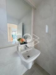 Modern bathroom interior with pedestal sink and decorative flowers