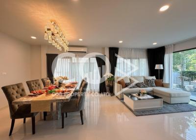 Spacious and well-lit combined living and dining area with modern furnishings and large windows
