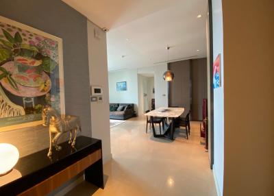Modern apartment interior with open plan living space, dining area, and artistic wall painting