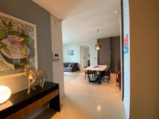 Modern apartment interior with open plan living space, dining area, and artistic wall painting