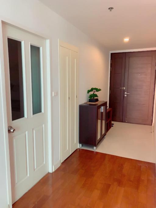 Bright hallway interior with wooden flooring and white doors