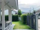 Exterior view of a home showcasing the driveway and lawn with a gated entrance