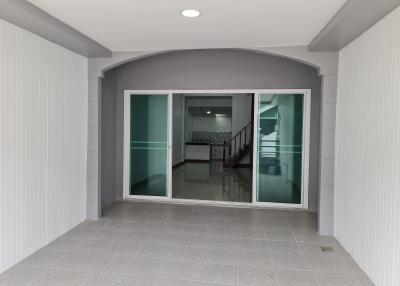 Modern entrance with gray tiles leading to a bright, open-concept kitchen