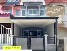 Two-story residential building with a grey gate and balcony